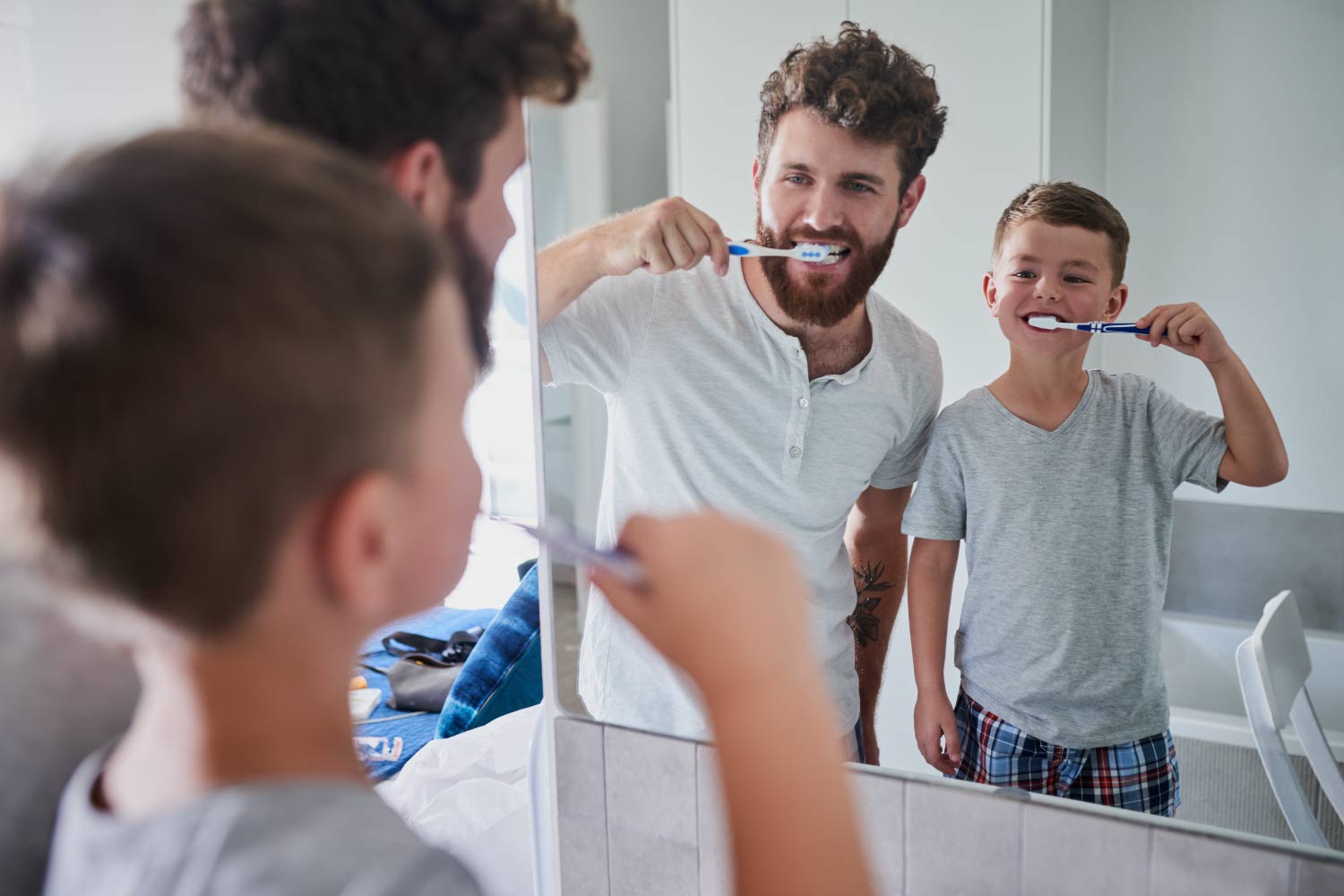 Dad brushes his teeth with his son, making oral hygiene fun for his kids