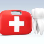 A red first aid kit next to a white tooth to indicate a dental emergency in Denver, CO